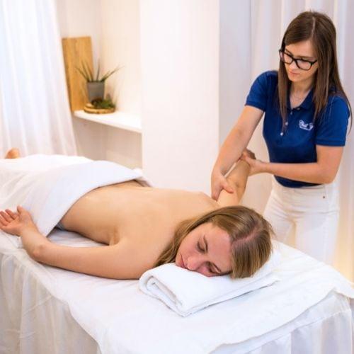 Kobieta relaksująca się podczas masażu abhyanga wykonywanego przez terapeutkę spa