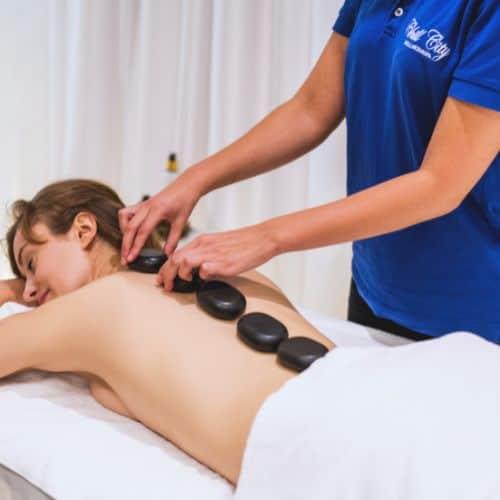 Klientka spa relaksująca się podczas masażu ciepłymi kamieniami